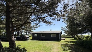 A small, dark-colored house with a grassy yard, surrounded by trees. - "Vilmar" - 450m from the sea by Interhome (Nykøbing Sj)