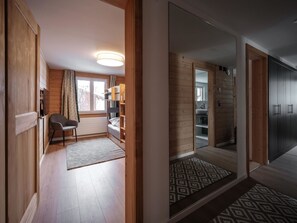 Ein modernes Interieur mit Holzboden, einem Bett, einem Schreibtisch und einem Stuhl.