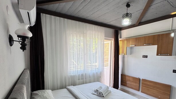 Un dormitorio moderno con una cama grande, una lámpara de pared y una lámpara colgante.