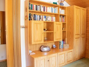 A wooden cabinet with multiple shelves, a radio, and a basket. - Haus Christina Dohlengiebel Appartement/Fewo, Dusche und Bad, WC, 3 Schlafräume by Interhome (Arosa)