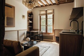 A room with a wooden ceiling, a window with decorative glass, a sink, a chair, and a bookshelf. - Cosy Apt A/C 1ch/4p - Montmartre / Place du Tertre (Paris)