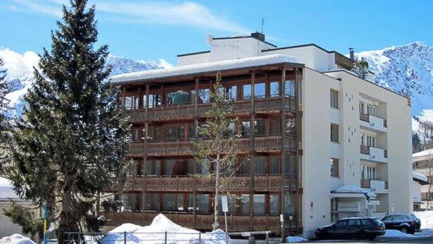 A multi-story hotel with balconies, a snow-covered ground, and a mountainous backdrop. - Luegisland Wohnung Salietti Appartement/Fewo, Dusche oder Bad, WC, 8-Bettwohnung by Interhome (Arosa)