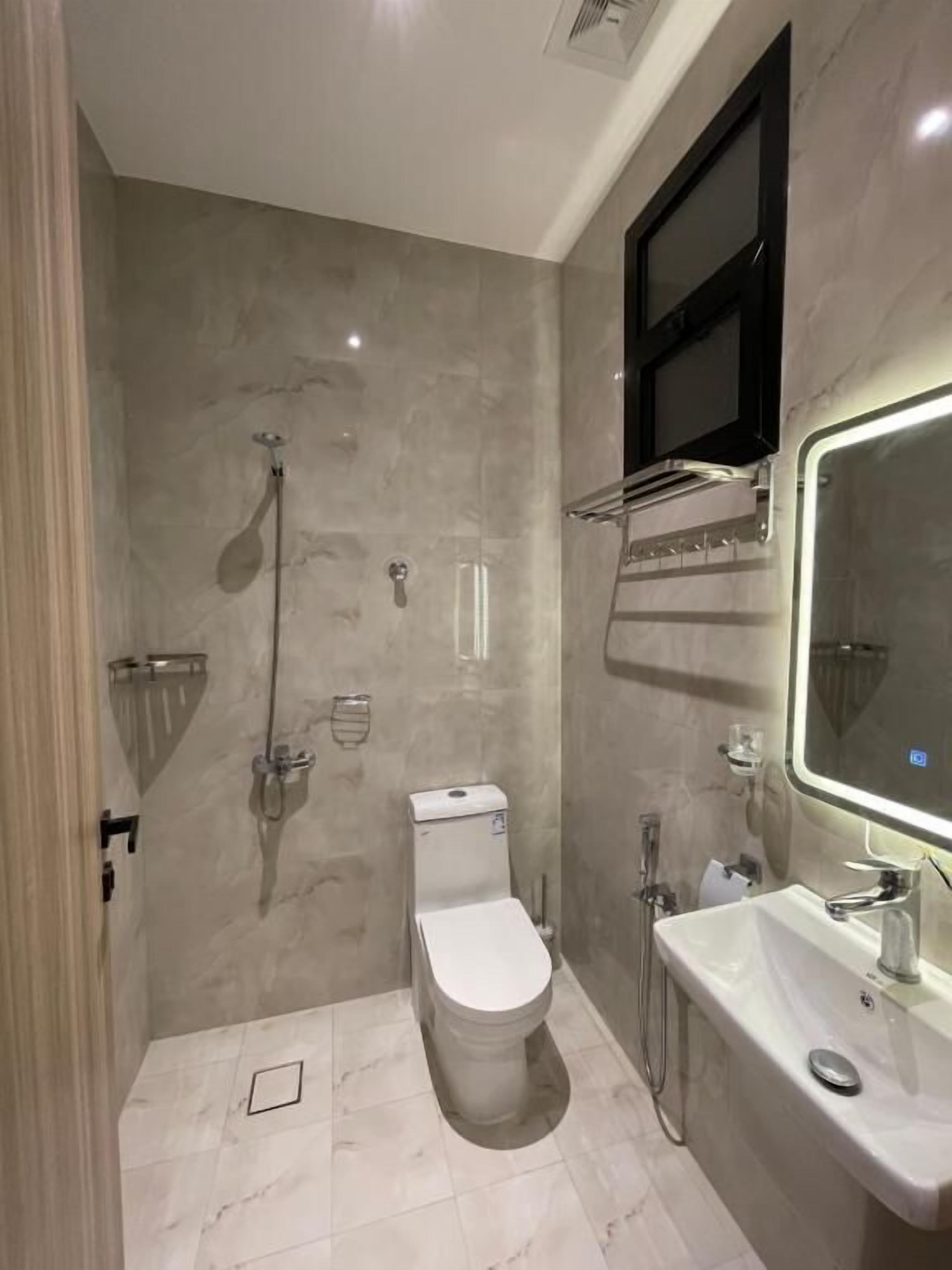 Une salle de bain moderne équipée de toilettes, d’une douche et d’un lavabo.