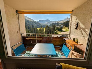 A balcony with a table and chairs, a view of mountains, and a rustic decor. - Rothornblick 63 by Arosa Holiday Appartement/Fewo, Dusche, WC Rothornblick 63 by Interhome (Arosa)