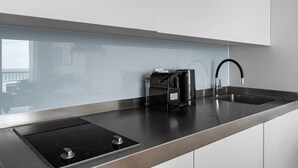 Une cuisine moderne équipée d’une cuisinière intégrée, d’une machine à café et d’un évier.