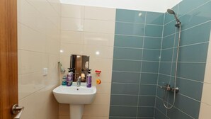 A bathroom with a sink, toiletries, and a shower. - Perfect 3-bedroom apartment with AC in welcoming West B Zanzibar (West B, Zanzibar)