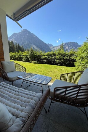 A balcony with outdoor furniture, a glass table, and a view of mountains. - Chesa Forma 2 by Arosa Holiday Appartement/Fewo, Dusche oder Bad, WC, 6-Bettwohn by Interhome (Arosa)