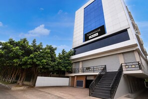 A modern building with a sign reading 'TOWNHOUSE' and 'OYO-Serviced'.