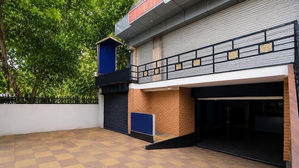 Een gebouw met een plat dak, een bakstenen gevel en een hekwerk.