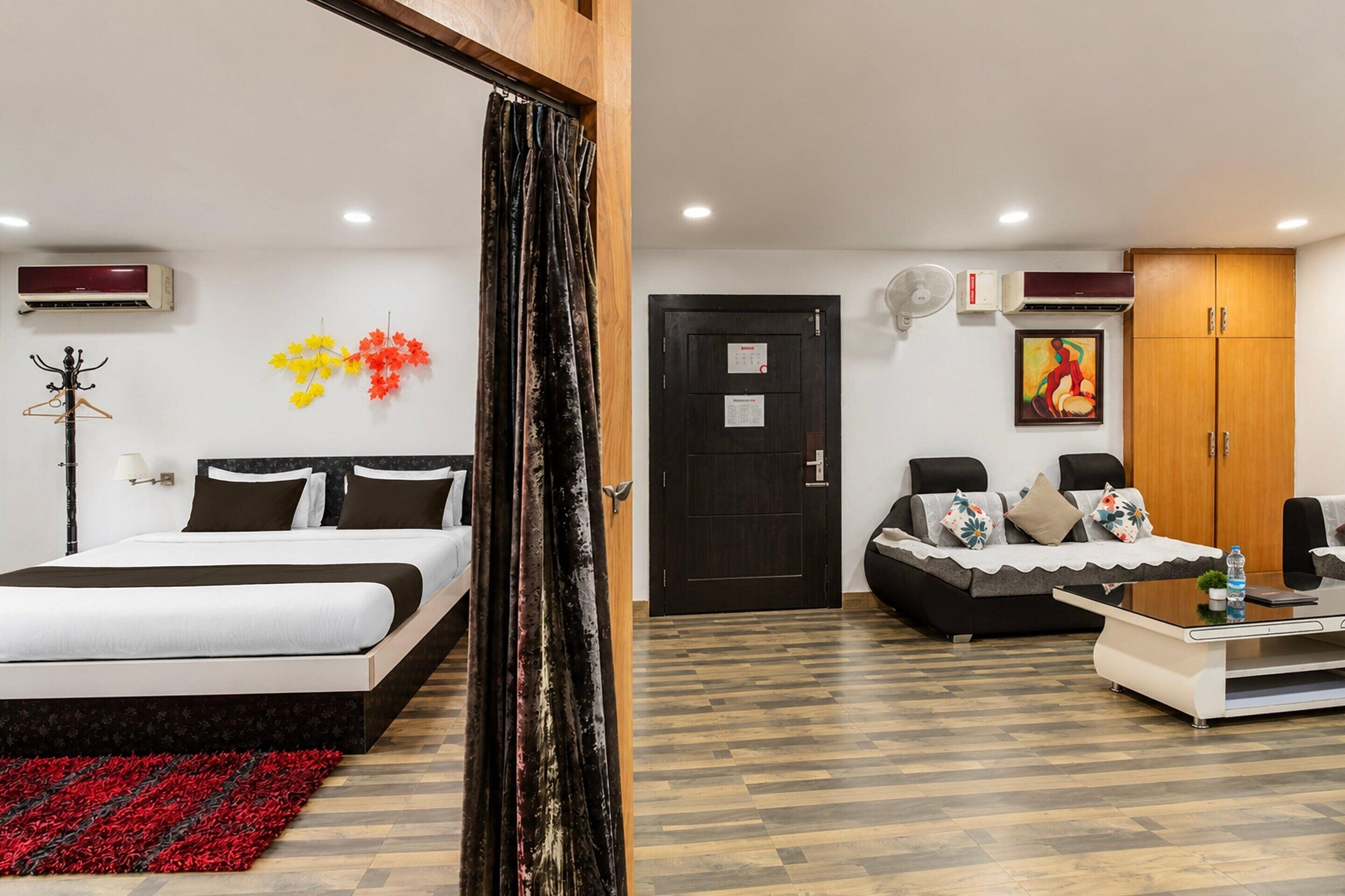 Habitación de hotel con cama, sofá, mesa de centro y armario.