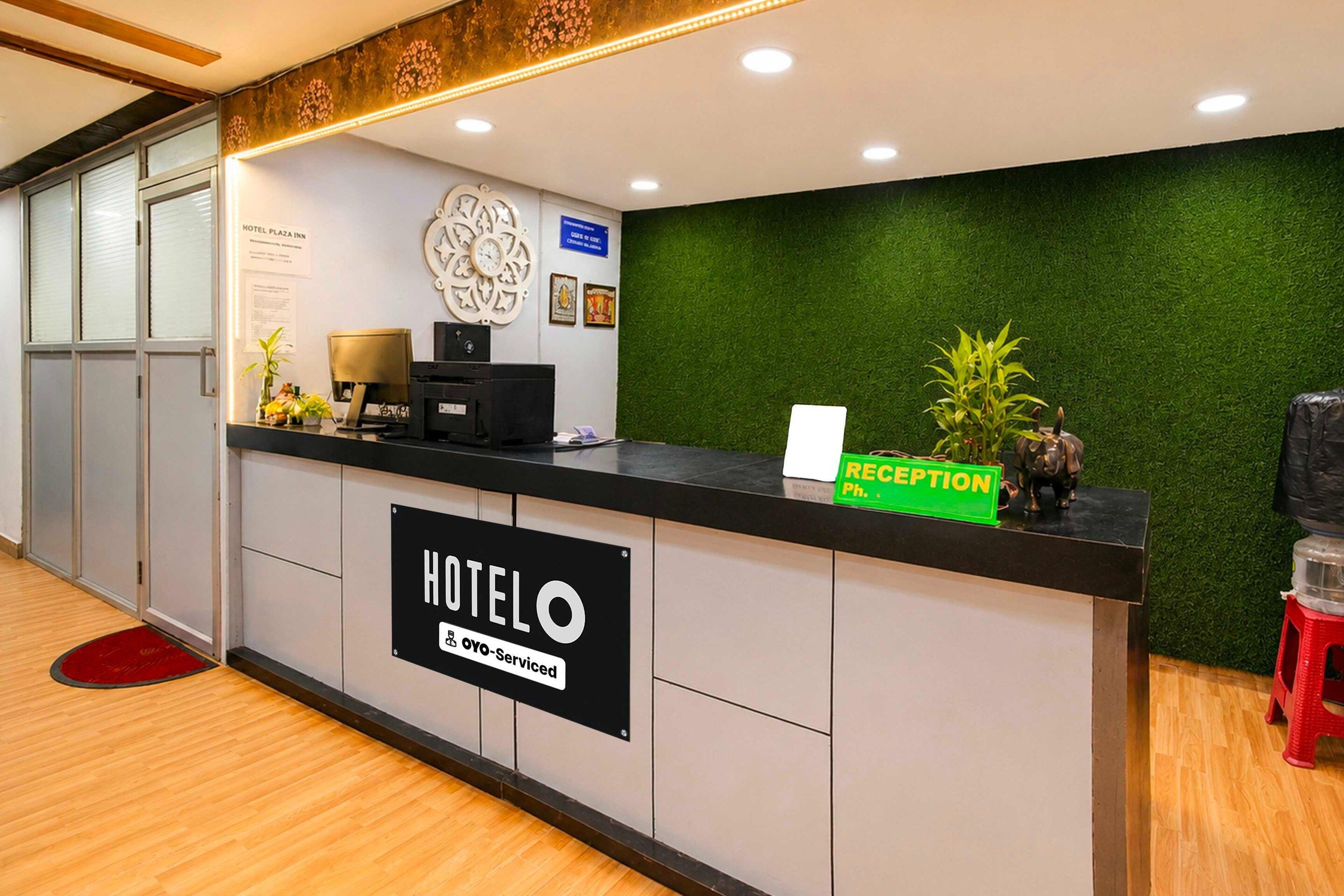 A hotel reception desk with a sign indicating it is serviced by OYO.