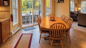Un espace repas comprenant une grande table, des chaises, un tapis et un luminaire suspendu au plafond.