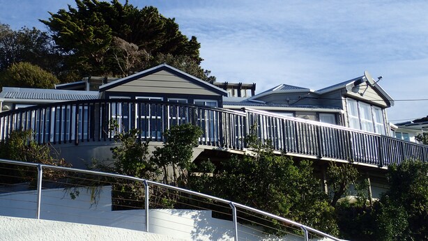 Un bâtiment moderne doté de grandes fenêtres, d’un balcon et d’une antenne parabolique.