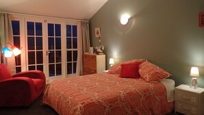 Une chambre à coucher avec un lit, des tables de chevet, une commode et une chaise.