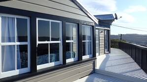 Un bâtiment doté de grandes fenêtres, d’un balcon et offrant une vue sur le paysage.