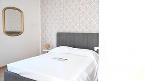 Ein Hotelzimmer mit Bett, rundem Tisch, Spiegel und einer Kristallleuchter.