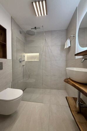 Ein modernes Badezimmer mit Dusche, Toilette und Waschbecken.