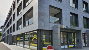 Moderni rakennus, jossa on kyltti, jossa lukee ’247Concierge’ ja ’Ylellisiä loma-asuntoja’.
