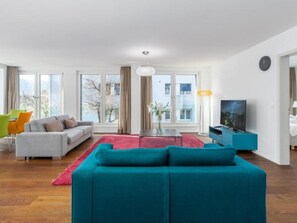 Un salon moderne avec un canapé, une table basse et un téléviseur.