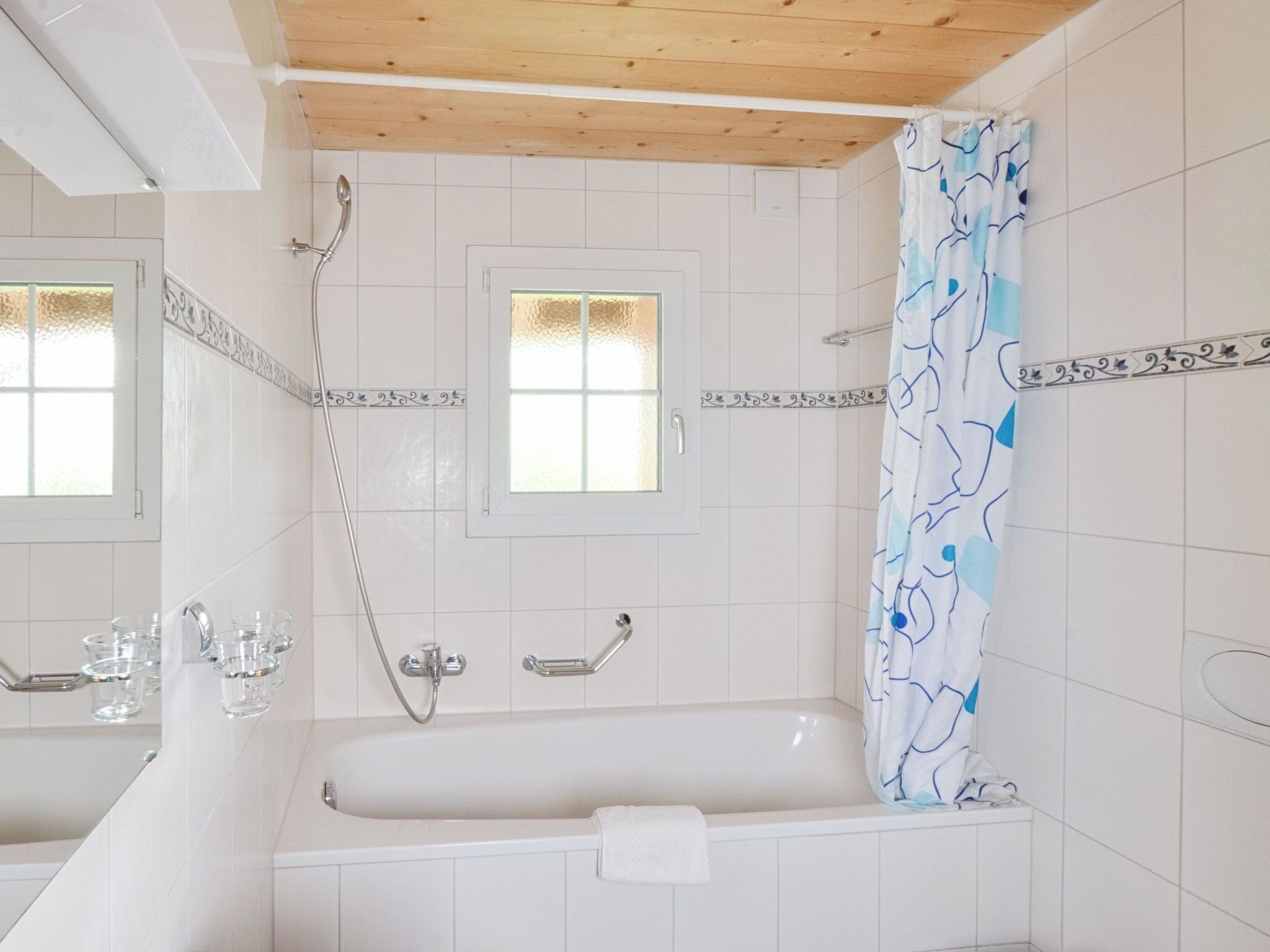 A bathroom with a bathtub, shower, and a window.