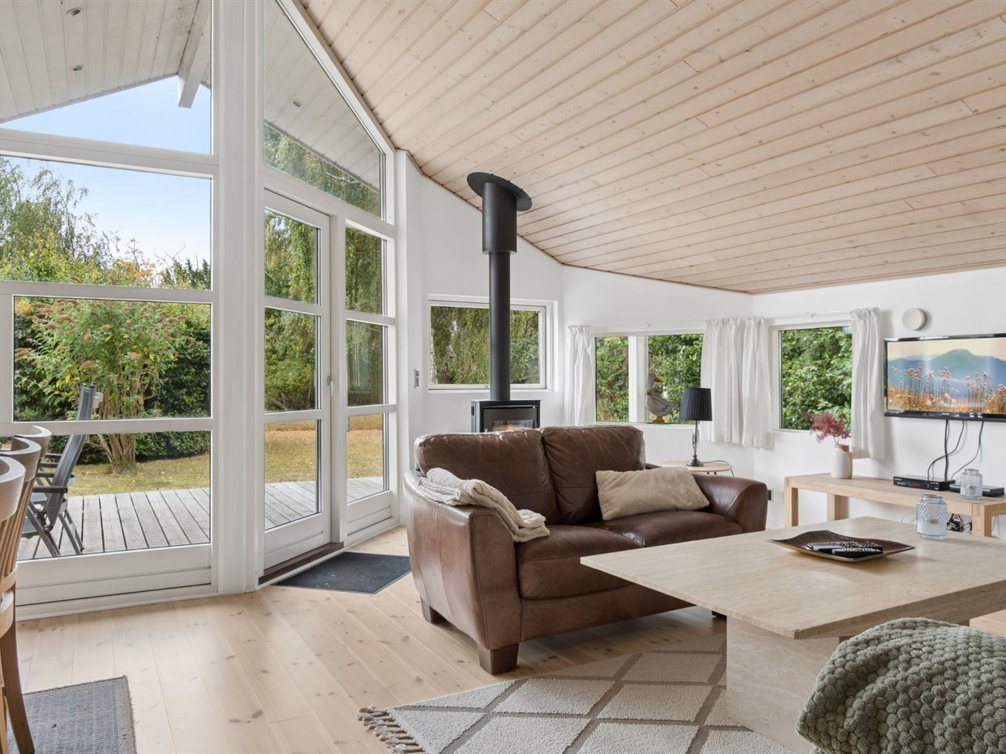 A spacious living room with a large window, a fireplace, a sofa, and a coffee table.