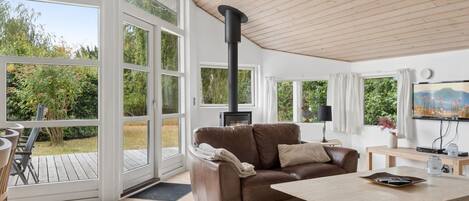 A spacious living room with a large window, a fireplace, a sofa, and a coffee table.
