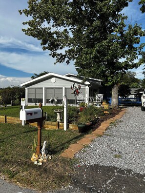 A residential property with a garage, a mailbox, and a well-maintained garden. - Coastal Retreat Charming and Salty in St. Andrews/Panama City Florida (Panama City)