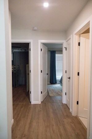 A hallway with wooden flooring leading to a room with a window and a curtain. - 3-bedroom Pool House in Sarasota/Bradenton
Close to Airport/Beaches/Shops/IMG (Sarasota)