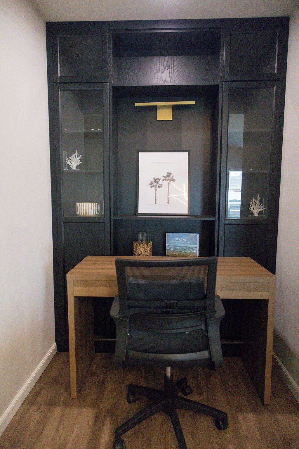 A workspace with a desk, chair, and shelving unit.