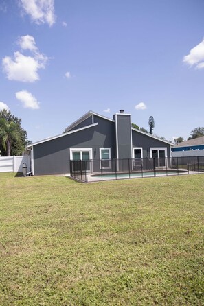 A modern building with a flat roof, a large garage door, and a fenced outdoor area. - 3-bedroom Pool House in Sarasota/Bradenton
Close to Airport/Beaches/Shops/IMG (Sarasota)