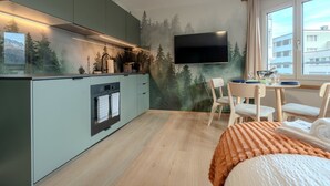 Eine moderne Küche mit eingebautem Ofen und einem Flachbildfernseher über der Arbeitsplatte.
