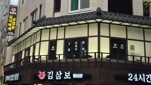 A building with a sign for 'Nana HOSTEL' and a traditional Korean restaurant with a sign '김삼보.' - Nana Hostel jonggak (Seoul)
