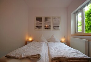 Une chambre à coucher avec un lit, deux tables de chevet et une fenêtre.
