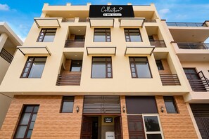 A multi-story building with a reception area, balconies, and a sign indicating it is serviced by OYO. - Classic Ganesha (Kharar)