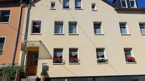 Un edificio de varios pisos con fachada plana, múltiples ventanas y una entrada visible con escalones.