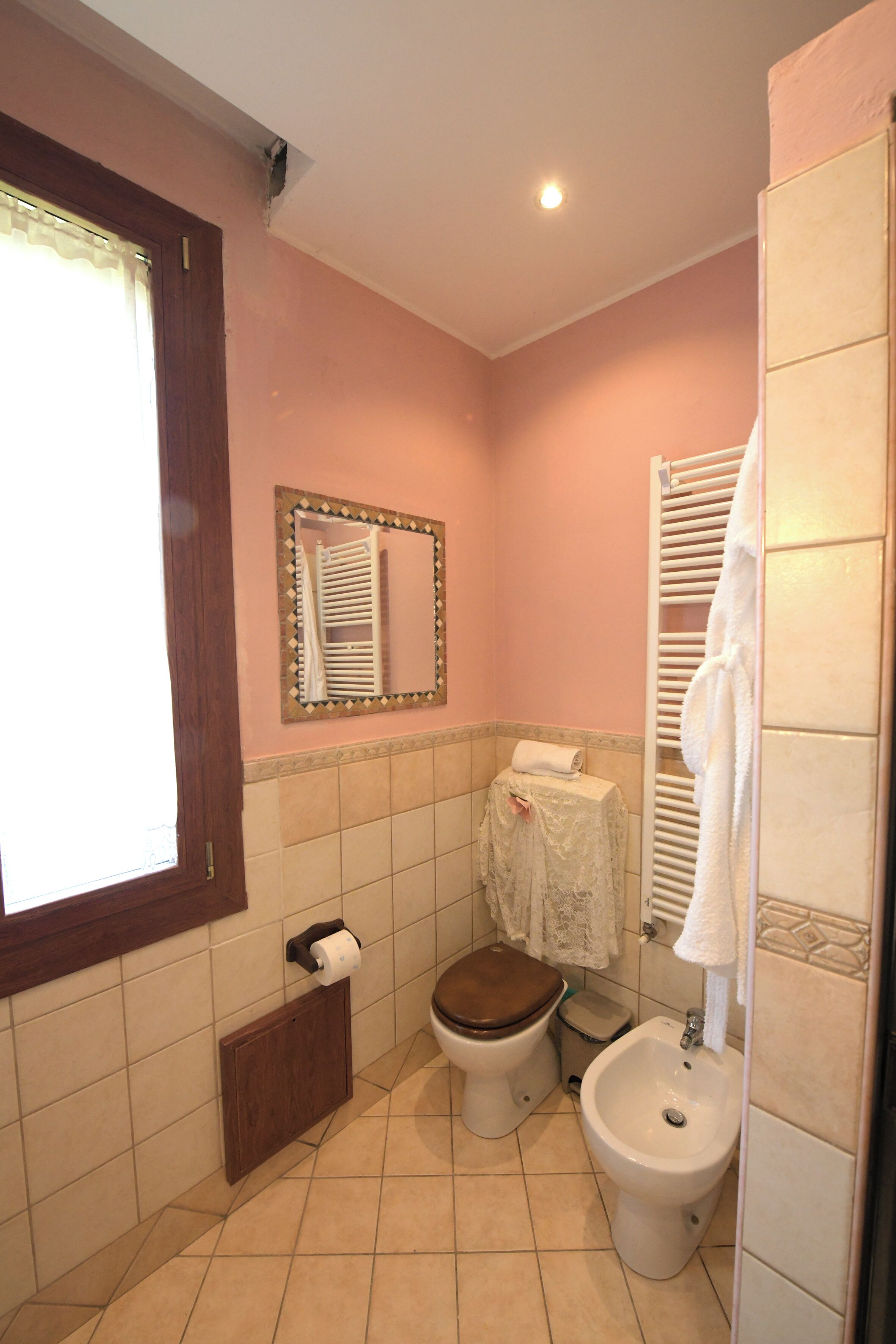 Un baño con inodoro, bidé y toallero.