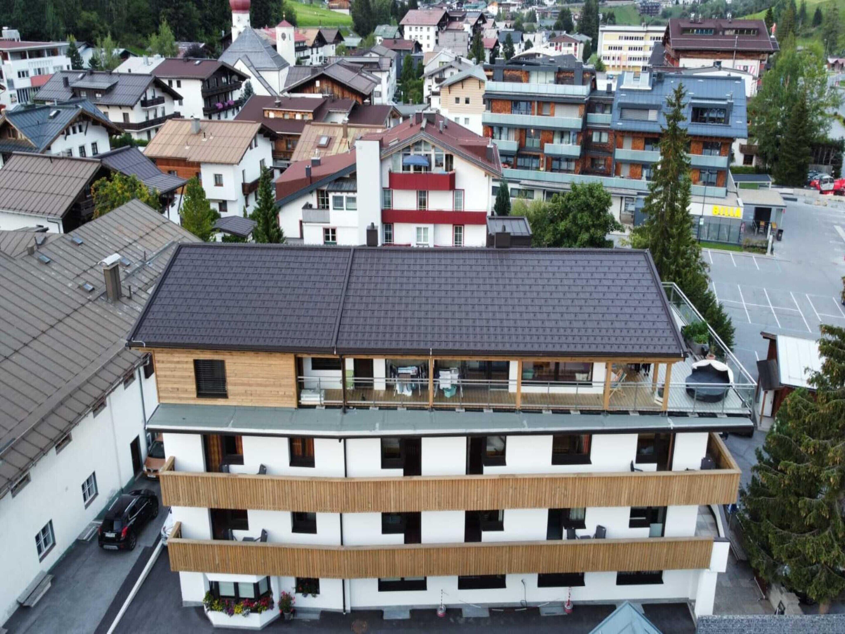 Un hôtel à plusieurs étages, doté d’un toit plat, de balcons et d’un espace de stationnement.