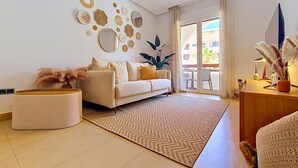Una sala de estar moderna con un sofá, una mesa de centro, un tapete y decoración en la pared.