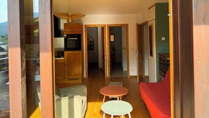 Ein modernes Interieur mit einer Küche, einem Essbereich und einem roten Sofa.