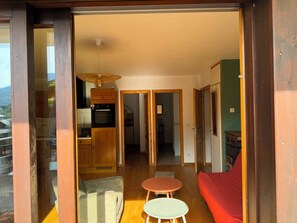 Ein modernes Interieur mit einer Küche, einem Essbereich und einem roten Sofa.