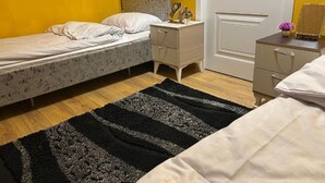 Une chambre à coucher avec un lit, des tables de chevet, une commode, une porte et un tapis.