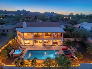 A two-story house with a swimming pool, outdoor seating, and a view of mountains. - MountainView Estate+HeatedPool+Spa+Firepits (Fountain Hills)