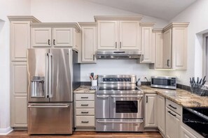 A kitchen with stainless steel appliances, beige cabinetry, and a granite countertop. - MountainView Estate+HeatedPool+Spa+Firepits (Fountain Hills)