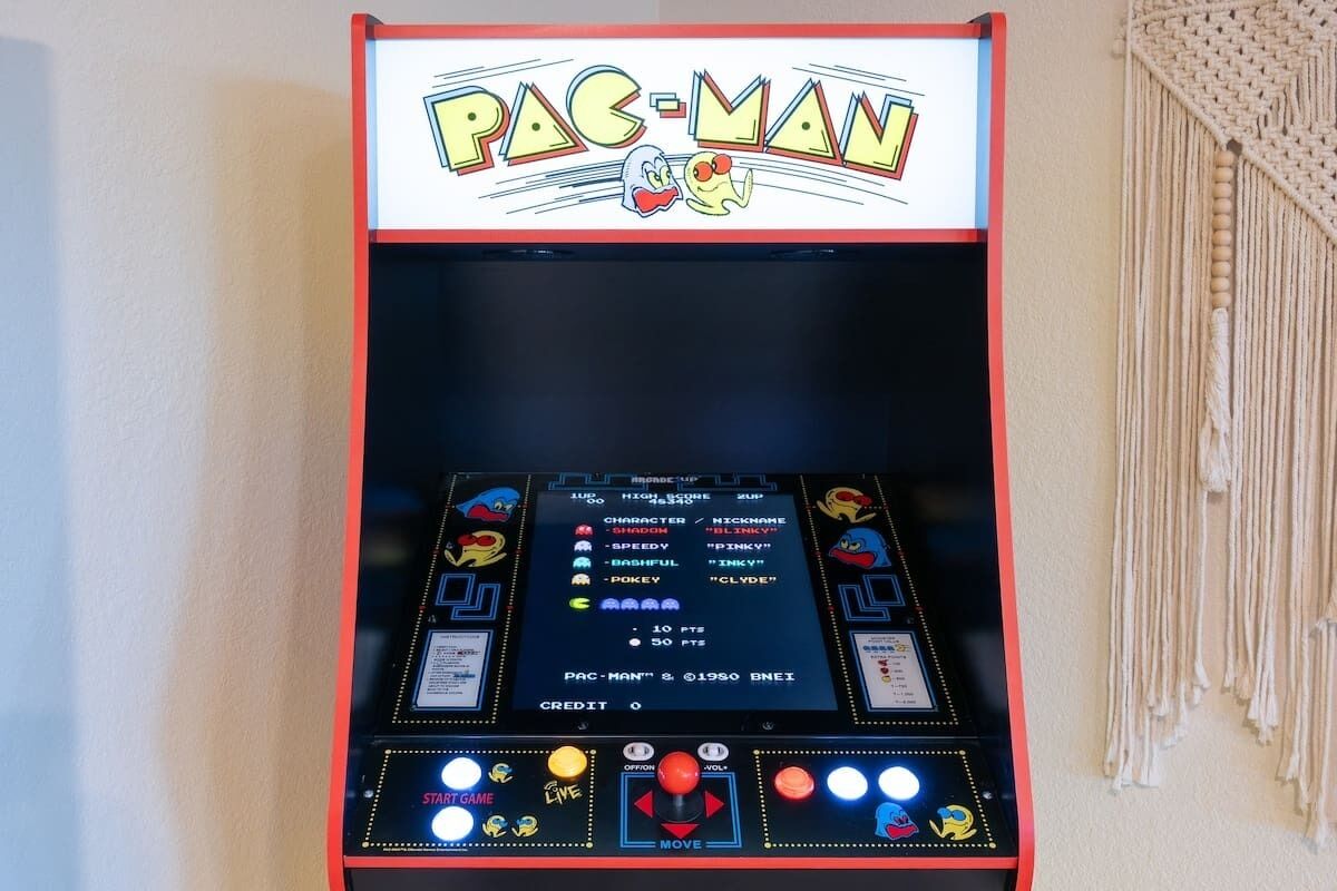 Ein Pac-Man-Spielautomat mit Punktestand, Figurenwahl und Steuerungstasten.