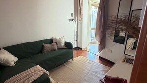 A living room with a green sofa, a white table, and a wooden ceiling. - A charming and modern apartment in the center of Teulada, just a few minutes from the beach (Teulada)