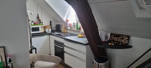 A compact kitchen with a microwave, coffee maker, and a Coca-Cola sign on the wall. - Notre Dame de Recouvrance: View of the Loire + Garage (Orléans)