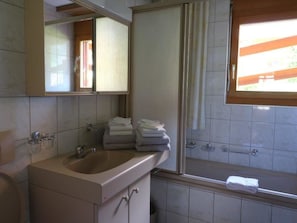 A bathroom with a sink, mirror, and a window. - Adlerhorst Leukerbad # 6-bed apartment, Bad, WC by Interhome (Leukerbad)