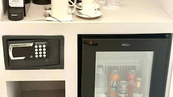 Un minibar con cafetera, microondas, refrigerador con bebidas y caja de pañuelos.