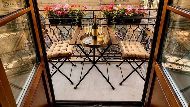 A balcony with a table set for two, a bottle of champagne, and a tray. - DISìO DIMORA DI CHARME (Palermo)