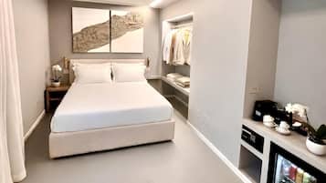 A modern bedroom with a large bed, a wardrobe, a bedside table, and a built-in TV.